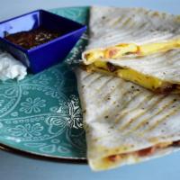 Breakfast Quesadilla · Shredded jack blend cheese, scrambled eggs, onion peppers, choice of bacon or sausage on flo...