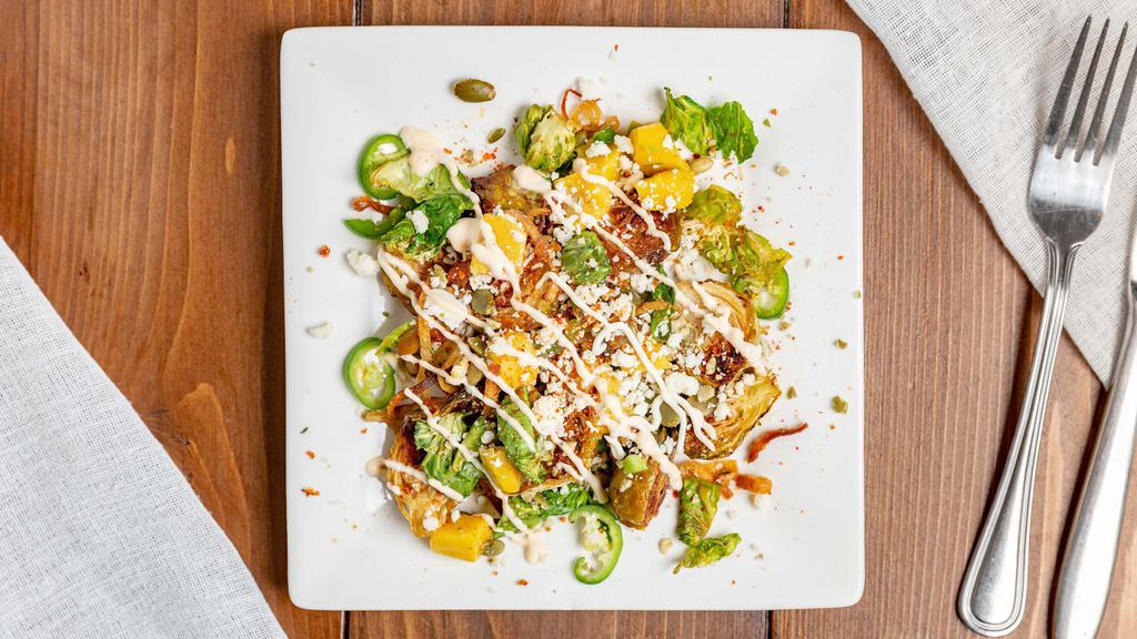 Tangy Brussels Sprouts · Roasted brussels sprouts seasoned with tajin & mango aioli, mangos, jalapenos, cotija, pepitas,