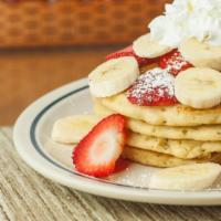 Strawberry Banana Pancakes · Four buttermilk pancakes with bananas inside, topped with fresh strawberries & bananas.