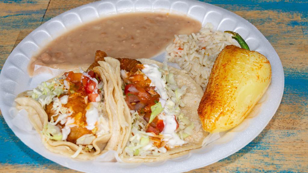 Dos Tacos De Pescado · Arroz frijoles y soda. 2 fish tacos, rice, beans, and soda.