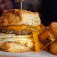 Sausage Sandwich · our sausage patty.  fried egg.  cheddar.  spicy aioli. biscuit.  fruit or potatoes.