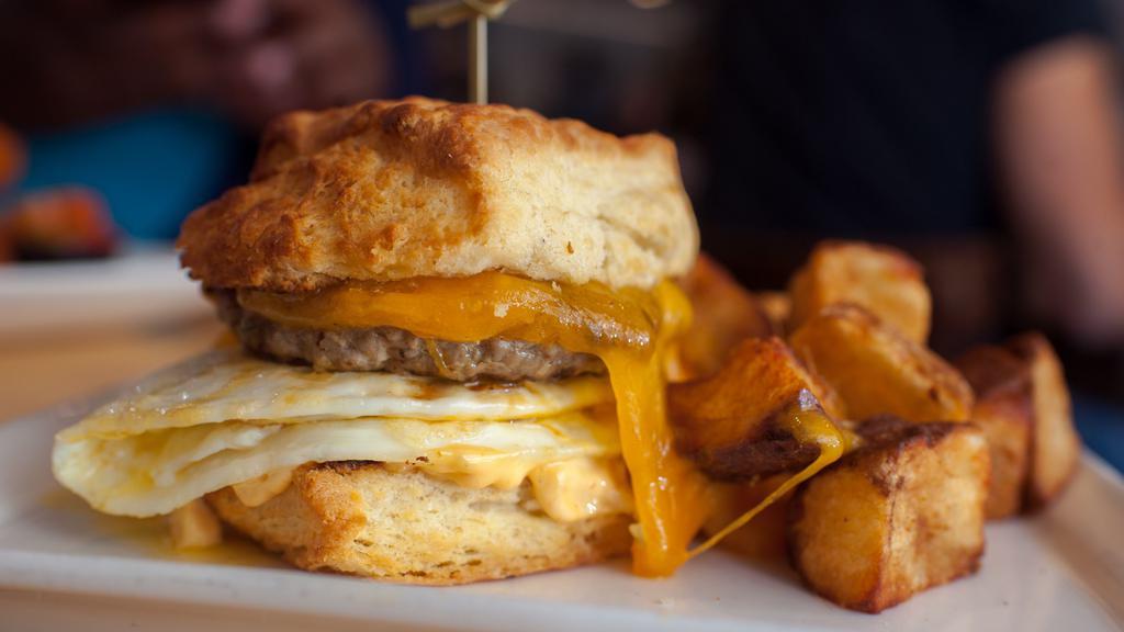 Sausage Sandwich · our sausage patty.  fried egg.  cheddar.  spicy aioli. biscuit.  fruit or potatoes.