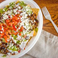 Super Nachos · Choice of meat, beans, cheese, guacamole, sour cream and tomatoes.