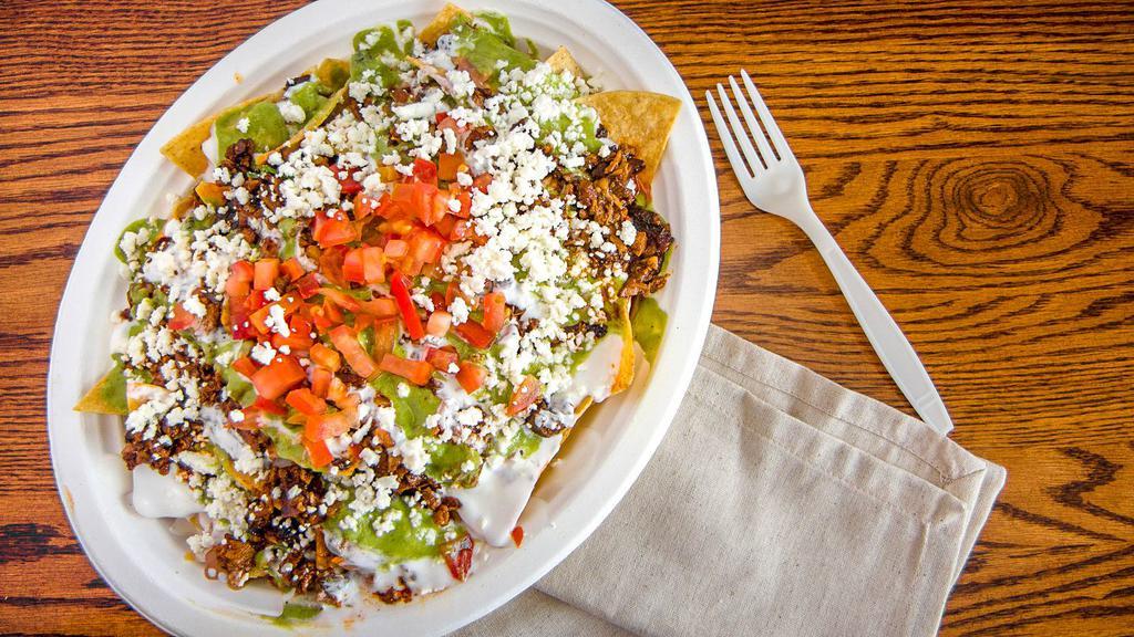 Super Nachos · Choice of meat, beans, cheese, guacamole, sour cream and tomatoes.