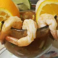 Cocktail De Camarones · An 18 oz. Glass filled with prawns cooked in their own juice mixed with diced tomatoes, onio...