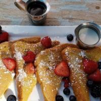French Toast · French brioche dipped in homemade batter, topped with fresh organic berries served with powd...