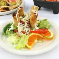 Taquitos Acapulco · Four corn tortillas rolled and filled with shredded beef, potato or chicken. Served on a bed...