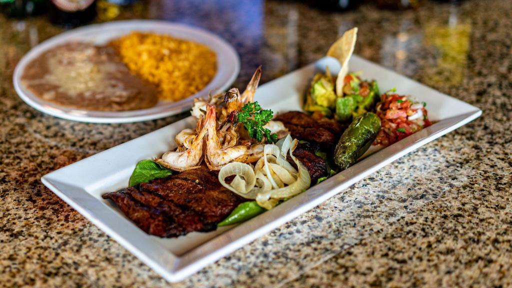 Mar Y Tierra · A 10 oz. skirt steak chargrilled to perfection topped with four jumbo shrimp, grilled onions, guacamole and pico de gallo. Served with tortillas.