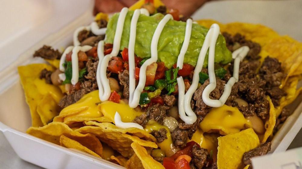 Loaded Nachos · Meat choice, homemade chips, topped with cheese sauce, whole beans, pico de gallo, sour cream & guacamole.