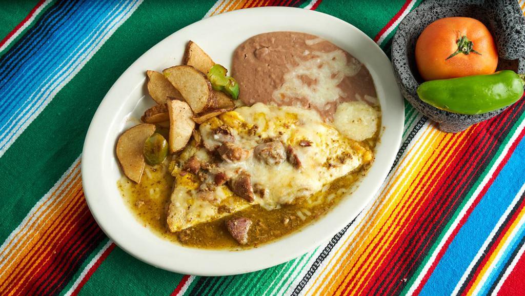 Chile Verde Omelette  · Chile verde and cheese inside the omelette topped with chile verde sauce and cheese served with beans and fried potatoes.