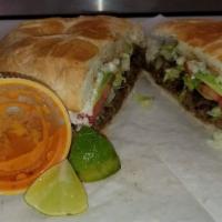 Torta · Mexican bread, choice of protein, refried beans, sliced onion, slice of avocado, slice of to...