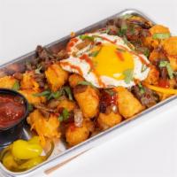 Tijana Tots · Tater tots topped with a fried egg, carne asada, cheddar cheese, grilled onions and salsa.