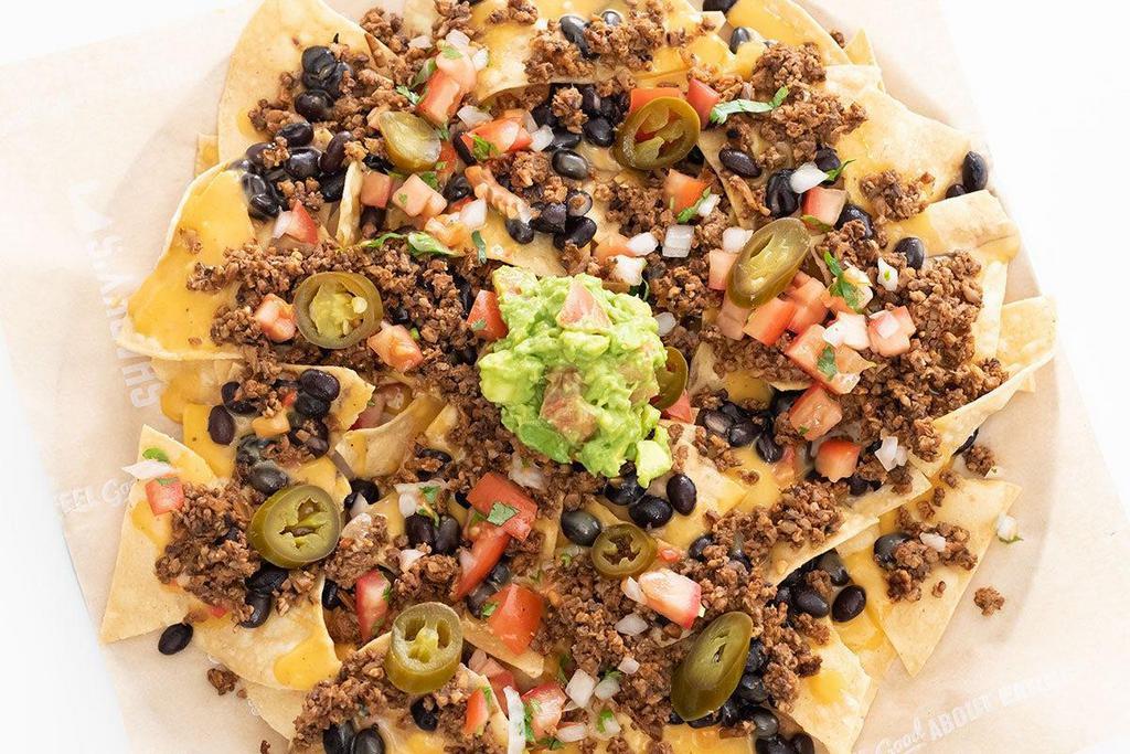 Plant Based Nachos Supreme · Chips smothered in our house queso topped with black beans, Screw Moo™ plant based protein,. guacamole, pico de gallo, and sliced jalapeños