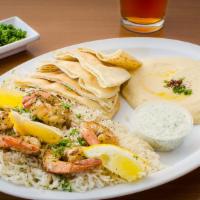 Shrimp Kabobs · Marinated shrimp sautéed & grilled, served with rice, HUMMUS, greek salad, pita bread and tz...