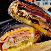 Cuban Sandwich  · The Famous Cuban Sandwich 
Mojo Marinated Roasted Pork , Fried Ham, Provolone Cheese, Pickle...