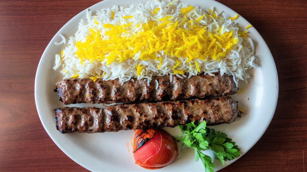 Chelo Kabob Koobideh · Two skewers of juicy strips of charbroiled seasoned ground beef served with basmati rice and charbroiled tomato.