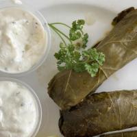Dolomathes · Grape leaves stuffed with seasoned ground lamb and rice. Served with tzatziki sauce.
