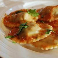Chicken Raviolis · Served with tomato, pink sauce, and fresh Parmesan cheese.