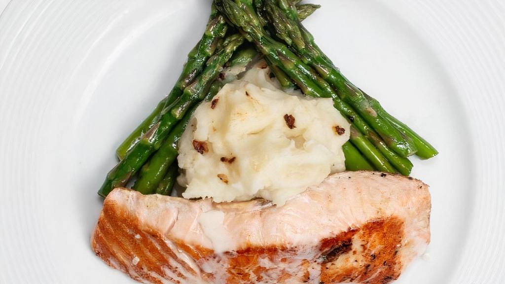 Fresh Grilled Salmon · Grilled salmon served over mashed potatoes asparagus and topped with lemon beurre blanc reduction sauce.