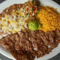 Carne Asada · Beef steak grilled to perfection. Served with refried beans and Mexican style rice. Garnishe...