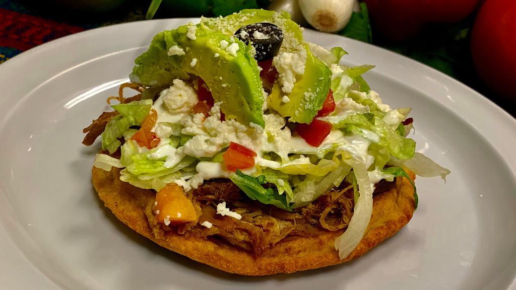 Sope · Meat beans onions lettuce Mexican cheese, sour cream. tomato, avocado slices, one olive.