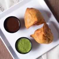 Vegetable Samosa · Two crispy fried turnovers deliciously filled with mildly spiced potatoes and green peas.