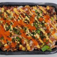 Sushi Bake · A baked sushi dish with crab salad and white rice.  Topped with green onions, masago,  furik...
