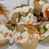 Dahi Puri · 7 puffed fried puris stuffed with potatoes, chickpeas, tamarind, and green chutney. Topped w...