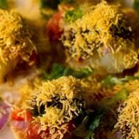 Sev Puri ( Vegan) · 7 puris stuffed with potatoes, onions, chickpeas, tamarind, and green chutney. Topped with s...