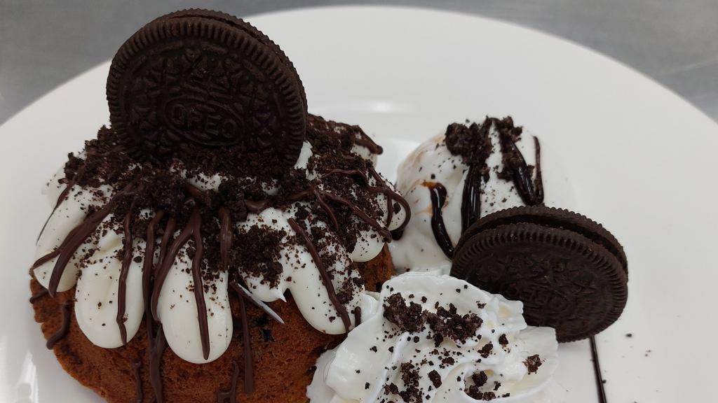 Cookies And Cream Delight · Delicious Cookies and Cream bundt cake covered in a rich Cream Cheese Buttercream, filled with nutella, and topped with Dark Chocolate drizzle and an Oreo cookie.  Served with Vanilla Ice Cream