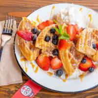 Churro Waffle · Classic Belgian waffle turned into a churro delight! Topped with fresh strawberries, blueber...