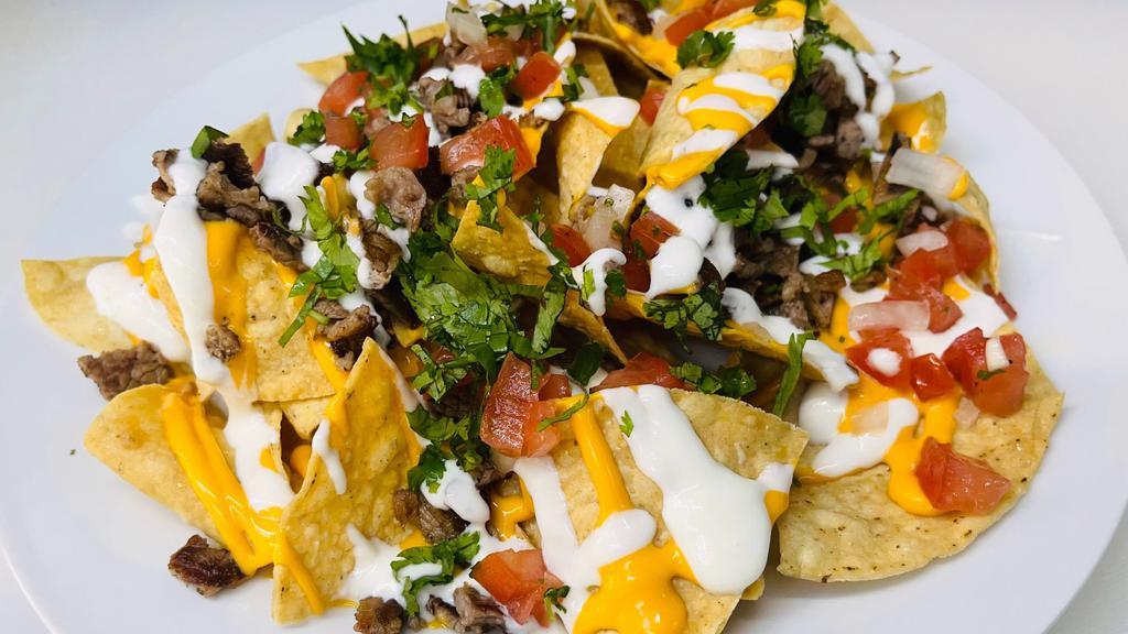  Nachos · tortilla chips, black beans, nacho cheese pico de gallon, sour cream, topped with jalapeños and your choice of meat.