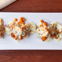 Mantoo · Steamed dumplings with beef and onions, topped with yellow split peas, yogurt, garlic and mi...