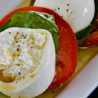 Caprese Salad · Roma tomatoes, burrata, basil, balsamic glaze, and extra virgin olive oil.