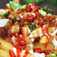 Asian Style Fries · A bed of fries coated with our creamy spicy ranch and regular ranch dressings, sriracha, gre...