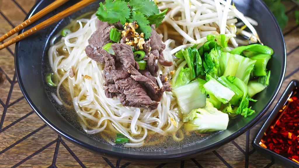 Thai Boat Noodle Soup · Tender sliced beef boiled with seasonal greens in a Thai style broth, all poured on top of a bed of thin rice noodles and bean sprouts. Garnished with roasted garlic, black pepper, green onions and cilantro.