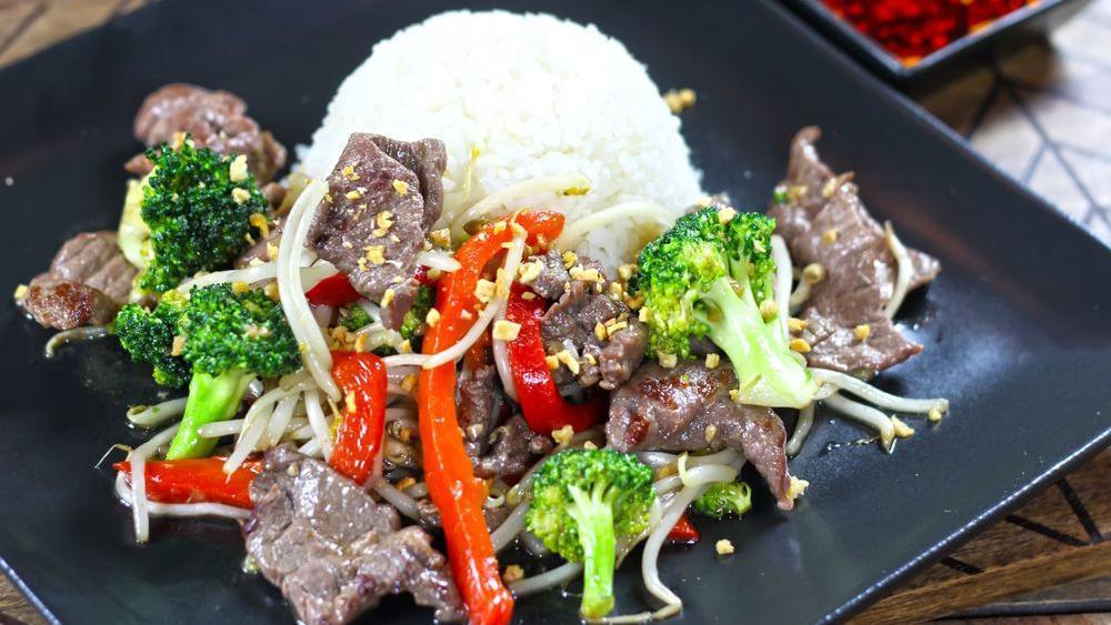 Flaming Broccoli · Sautéed with broccoli, bean sprouts and seasonal veggies in a spicy oyster sauce with fresh garlic, Thai chilies and jalapenos, served with a side of steamed white rice. Your choice of Sliced Beef or Shrimp. Garnished with roasted garlic, black pepper, green onions and cilantro.