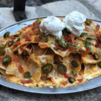 Mound Of Nachos · Warm tortilla chips topped with queso sauce, mixed cheese, spiced beans, pico de gallo, jala...