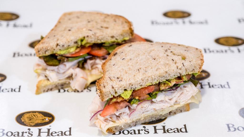 California Club · Roasted turkey, avocado, sprouts, applewood smoked bacon, tomato, Swiss cheese and herb marinated red onion.