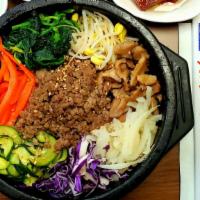 Stone Pot Bibimbap (돌솥비빔밥) · Stone pot rice topped with vegetables, beef, and egg, served hot.