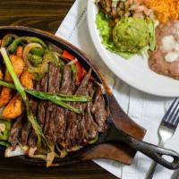 Sizzling Fajitas · Tender strips of chicken or certified Angus beef, served with bell peppers, green onions, an...