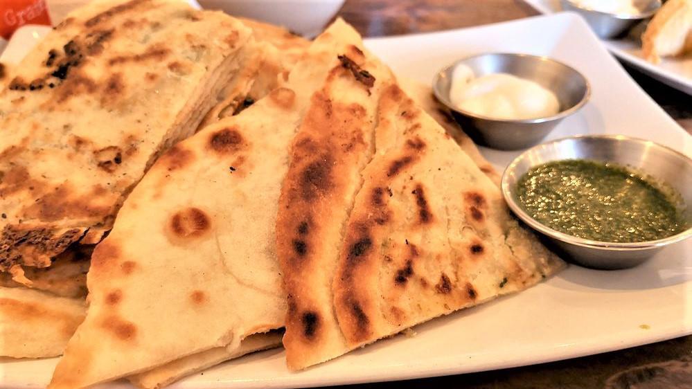 Bolani · House-made flatbread lightly pan fried filled with a potato mash of onion, garlic and cayenne pepper. Served with yogurt and green chutney.