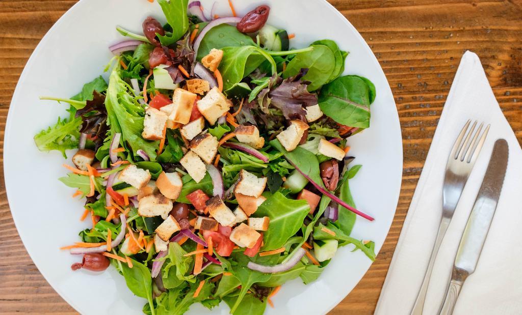 Loaded Green Salad · Mixed greens, fresh mint leaves, tomato, cucumber, red onion, Katamata Olives, julienne carrots and house-made naan croutons.