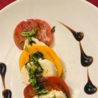 Mozzarella Caprese · Slices of fresh tomato, topped with fresh Italian buffalo mozzarella, basil, and virgin oliv...