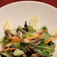 Insalata Alla Baci · Mixed greens salad with carrots, cucumbers, mushrooms, tomato, and red onions, served with I...