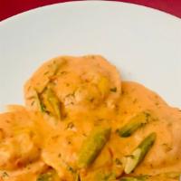 Ravioli Rossella · Ravioli stuffed with scampi in a lobster bisque sauce and asparagus.