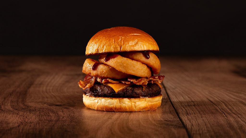 The Bacon Bbq Burger · Beef patty, bacon, fried onion rings, BBQ sauce, and melted cheddar cheese on a brioche bun.