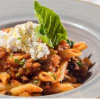 Penne Alla Norma · Penne pasta tossed with eggplant, onions, spicy tomato sauce, and served with ricotta cheese...