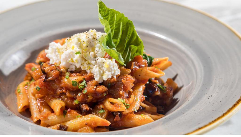 Penne Alla Norma · Penne pasta tossed with eggplant, onions, spicy tomato sauce, and served with ricotta cheese on top.