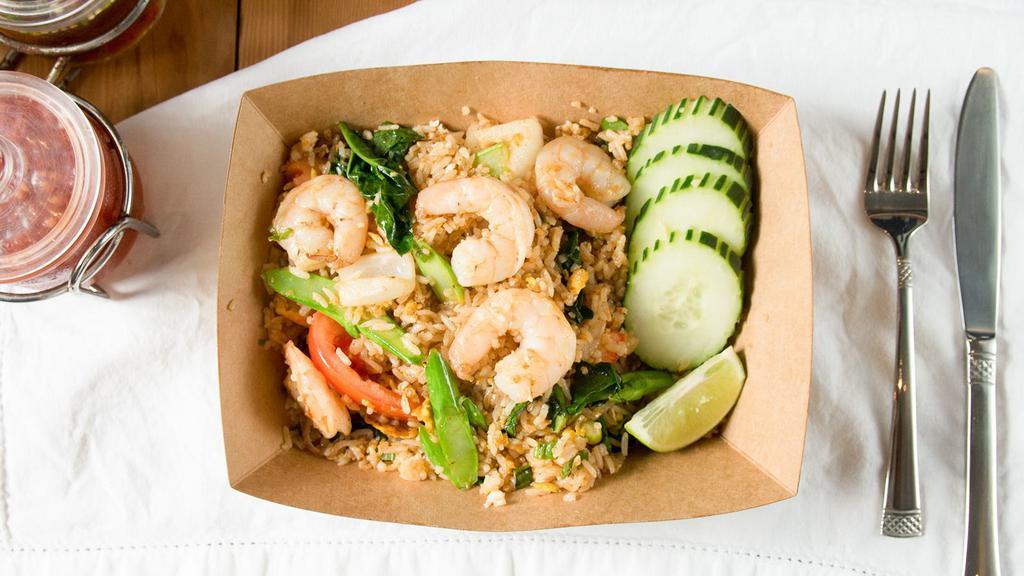 Thai Style Fried Rice · White rice stir fried with a soy sauce blend, egg, tomato, Chinese broccoli, and onion served with lime wedge and cucumbers.